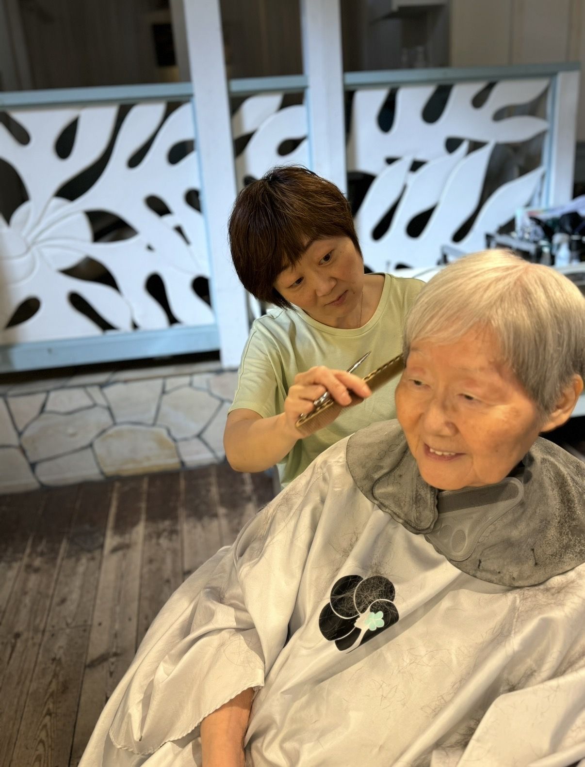 白髪のお客様の髪を丁寧に切るKiyo