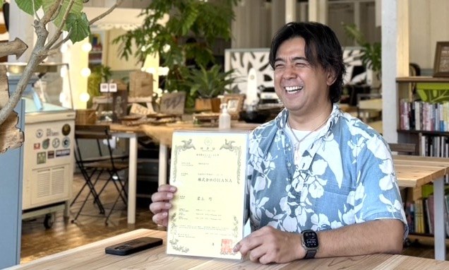 ハウオリの特許証を手に笑う岩上巧